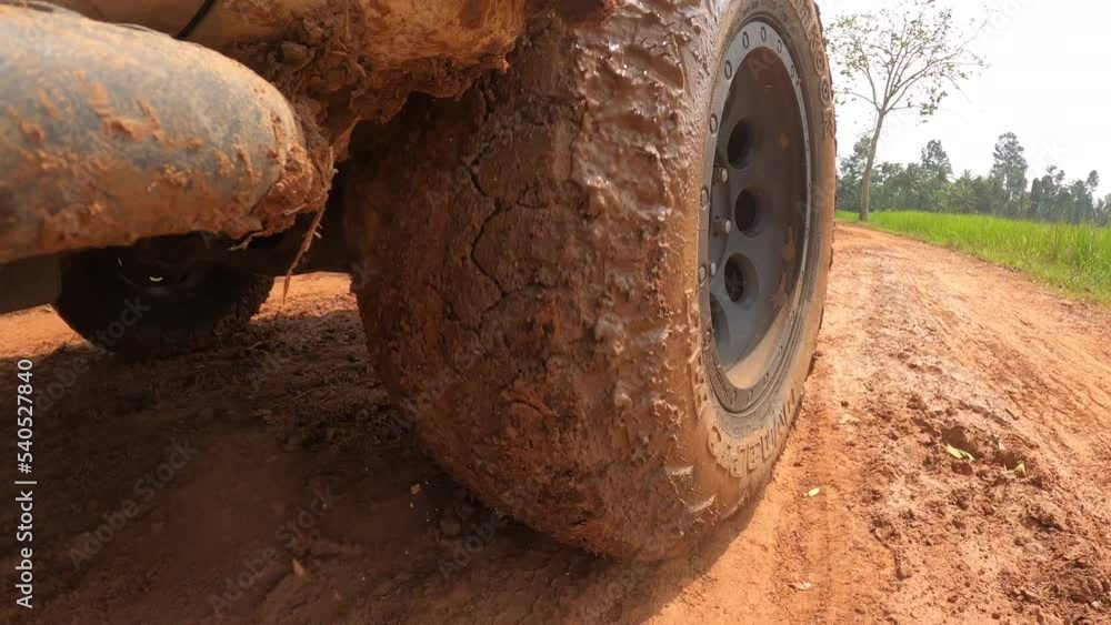 4x4 off road Pickup car wheels are running on a dirt road. Off-road truck car wheels moving on the dirty road with dust, wet and dry mud. Point of view 4WD truck tire travel in the backcountry place 4x4 off road Pickup car wheels are running on a dirt road. Off-road truck car wheels moving on the dirty road with dust, wet and dry mud. Point of view 4WD truck tire travel in the backcountry place