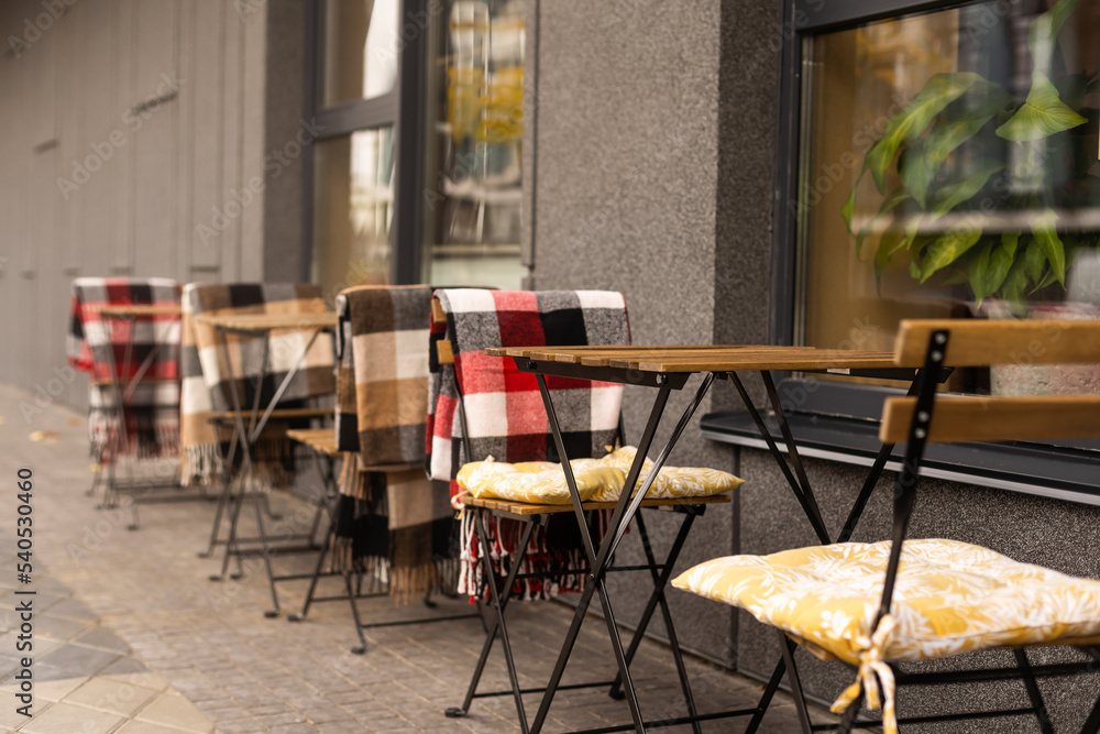 comfy seats in a street cafe with blankets