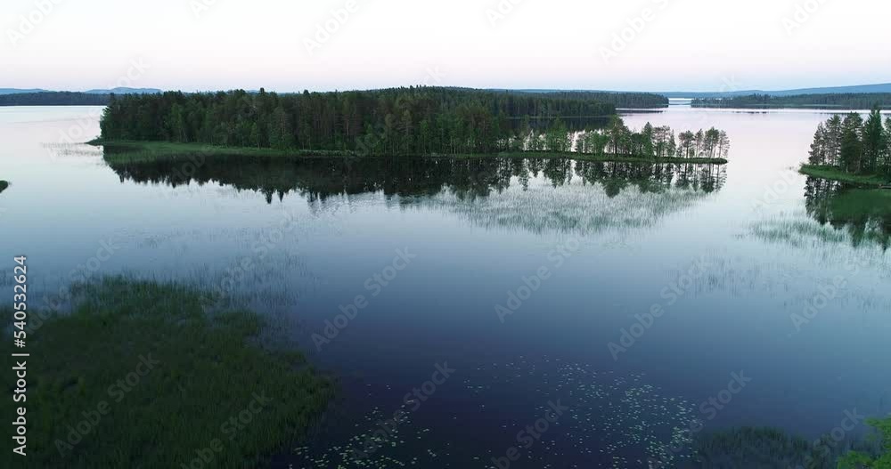Moving backwards and rising over a lake and islands on a late night in Northern Finland Moving backwards and rising over a lake and islands on a late night in Northern Finland