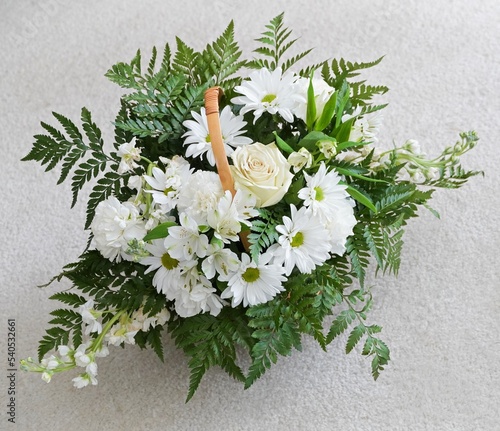 Beautiful floral arrangement with white flowers.  Gorgeous bouquet top-view with basket handle.