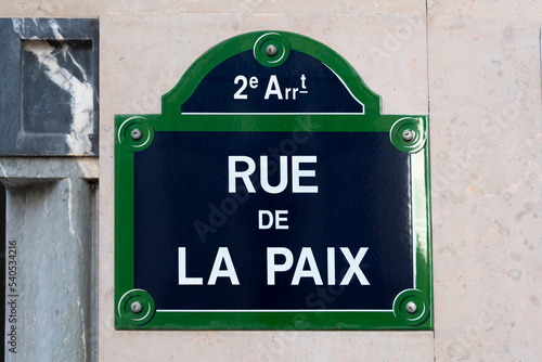 Фотография Plaque de rue parisienne traditionnelle sur laquelle est écrit Rue de la Paix,