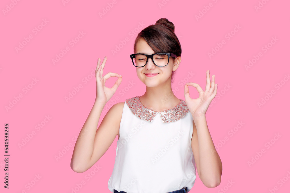 Girl against pink background showing ok gesture dreaming with closed eyes Girl against pink background showing ok gesture dreaming with closed eyes