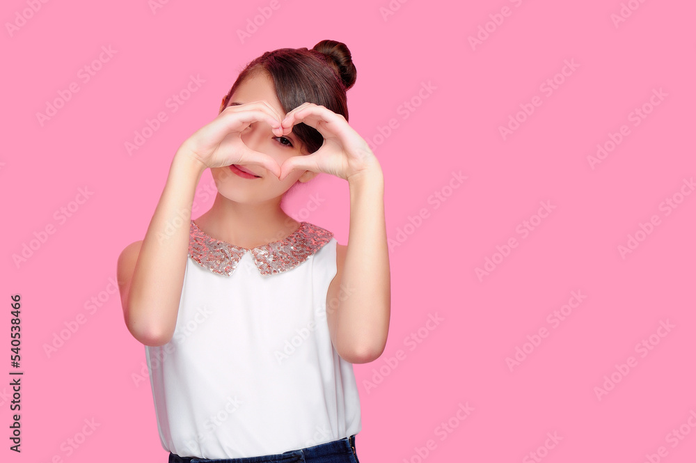 Pretty girl making with hands heart shape and looking through it Pretty girl making with hands heart shape and looking through it