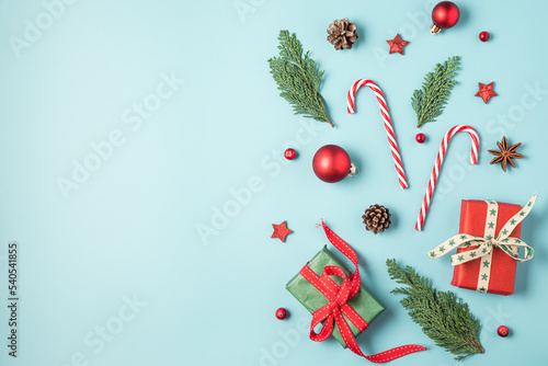 Christmas background with fir tree  holiday decorations  gift boxes on blue background. Flat lay. Top view