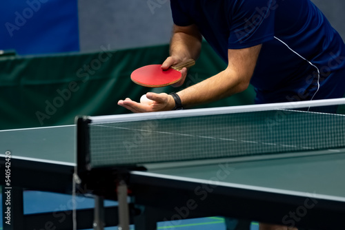 table tennis player serving, ball is in open hand