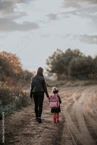 Obraz na płótnie Mama odprowadza córkę z plecakiem do przedszkola w salonie