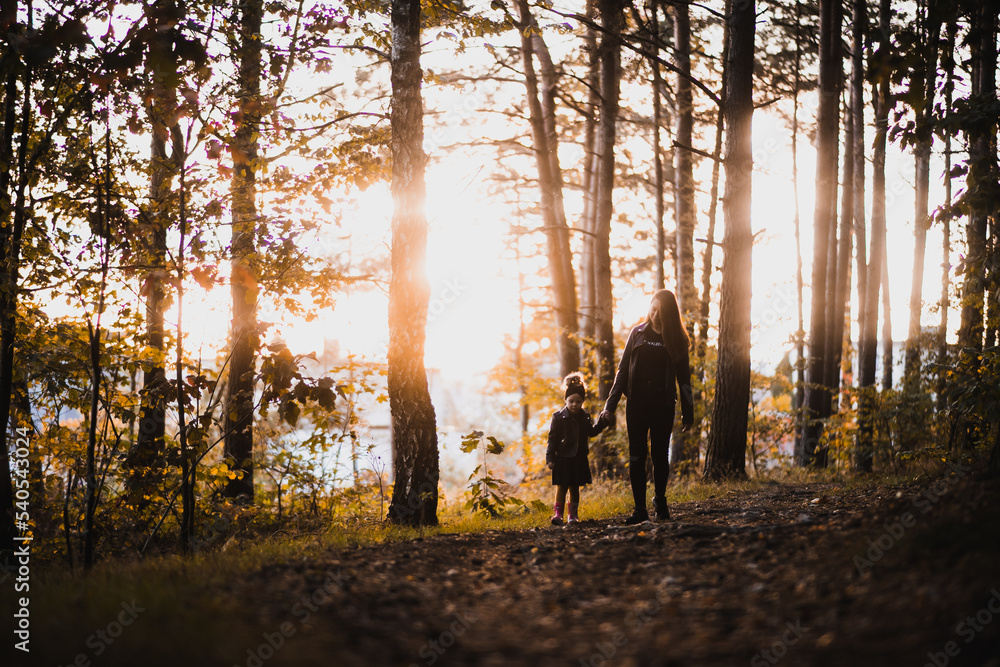 Mama i córka na spacerze o zachodzie słońca słonecznym lesie - obrazy, fototapety, plakaty 