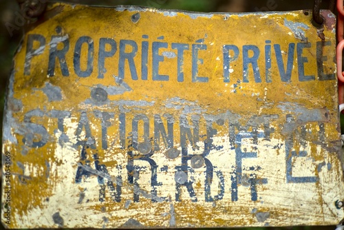 Panneau propriété privée stationnement interdit délabré abîmé par les intempéries