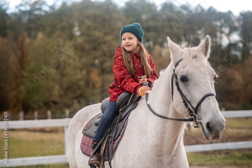 girl is riding a white horse and smiling 