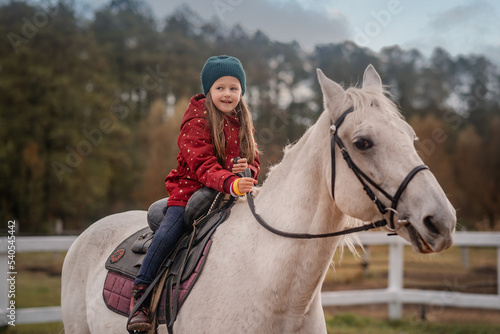 girl is riding a white horse and smiling 