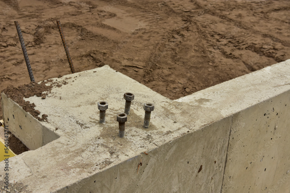 Concrete footings and foundation with anchor bolts ready for further