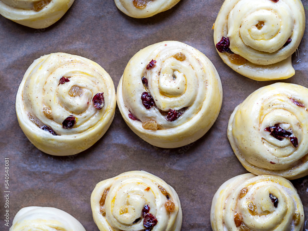 Gluten-free buns made of rice and corn flour with cinnamon, raisins and cranberries. The concept of proper nutrition, gluten-free diet, healthy home baking.Top view. Gluten-free buns made of rice and corn flour with cinnamon, raisins and cranberries. The concept of proper nutrition, gluten-free diet, healthy home baking.Top view.