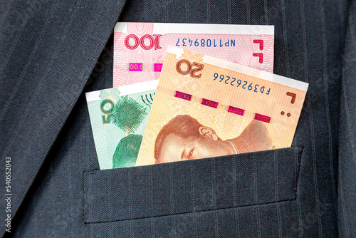Banknotes of Chinese currency in business suit pocket
