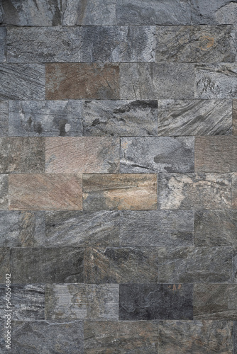 Wall made of various stone blocks. Vertical texture.