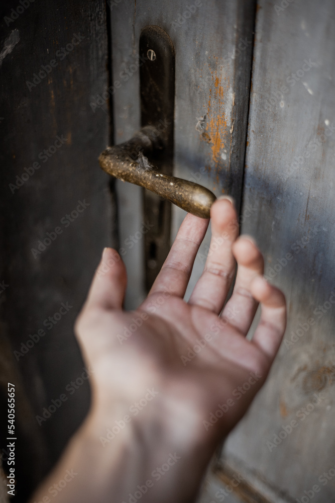 Hand reaching for a handle of a door Hand reaching for a handle of a door