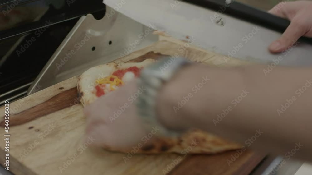 Oven baked pizza being sliced Oven baked pizza being sliced