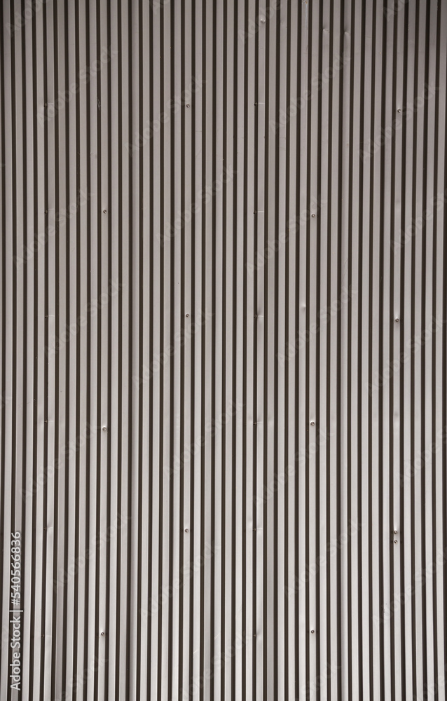 The texture of the metal pitched roof of a one-story building, metal strips on the roofing The texture of the metal pitched roof of a one-story building, metal strips on the roofing