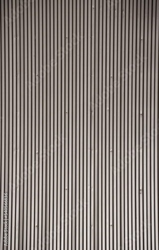 Fototapeta Naklejka Na Ścianę i Meble -  The texture of the metal pitched roof of a one-story building, metal strips on the roofing