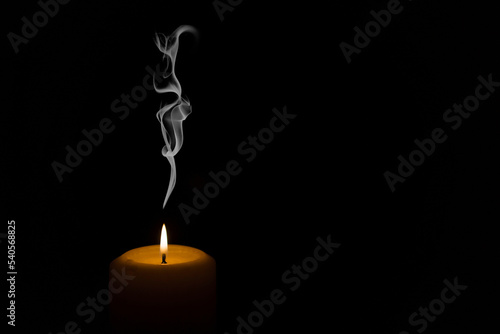 burning candle on black background with smoke