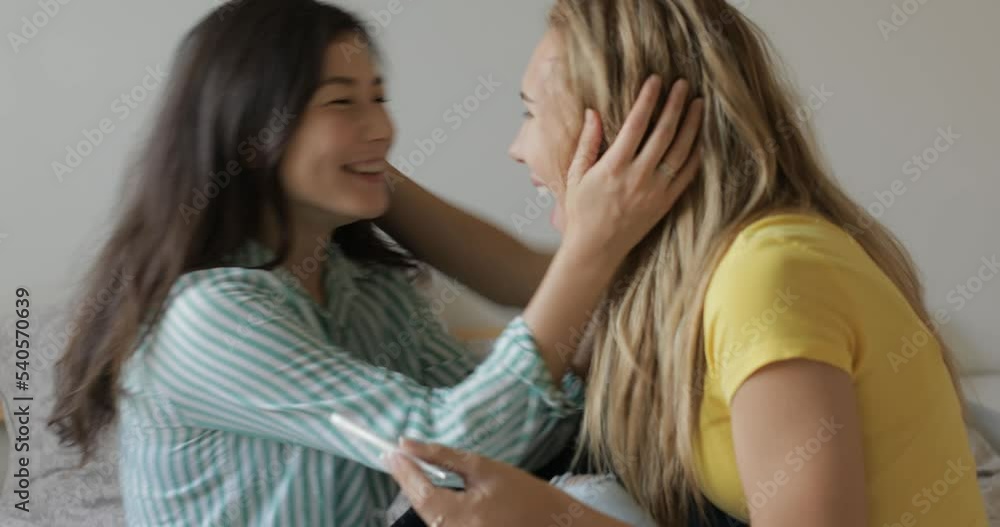 CRANE SHOT portrait of two lesbians look at the pregnancy test and rejoice. hugging and laughter CRANE SHOT portrait of two lesbians look at the pregnancy test and rejoice. hugging and laughter