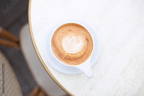 A cup of cappuccino on a patio table. Flat lay, selective focus