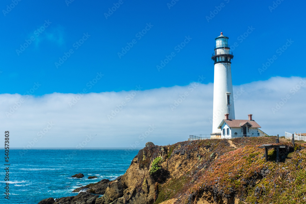 Bright lighthouse on the northern California coast with smooth cloud formation