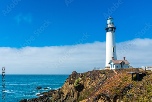 Bright lighthouse on the northern California coast with smooth cloud formation