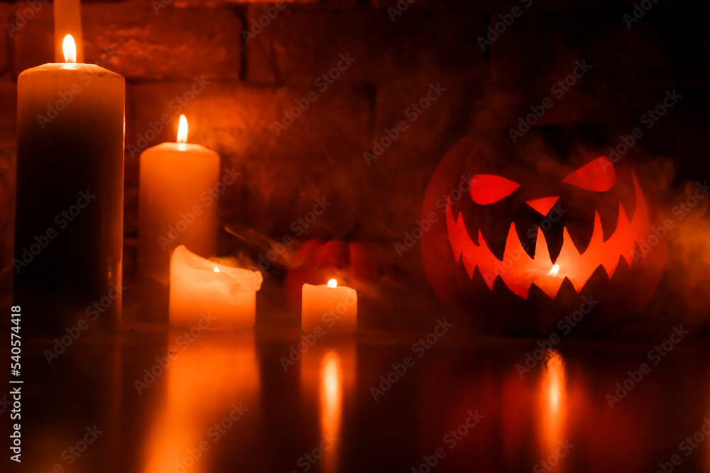 Halloween's holiday attributes. Halloween. carved pumpkin. candles . smoke . dark scene. pumpkin head silhouettes.