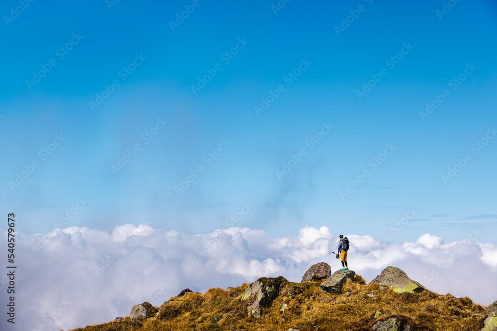 青空と雲と石だらけの登山道