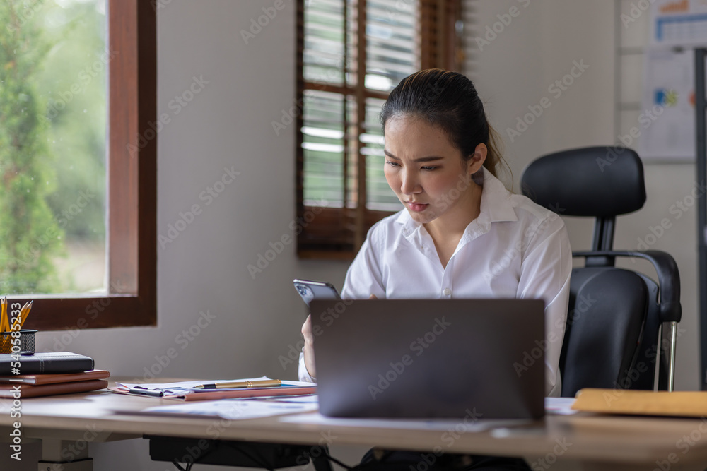 Young business Asian woman stressed while working, Tired asian businesswoman with headache at home office, payment stressed and confused by calculate expense from invoice or bill tax. Young business Asian woman stressed while working, Tired asian businesswoman with headache at home office, payment stressed and confused by calculate expense from invoice or bill tax.