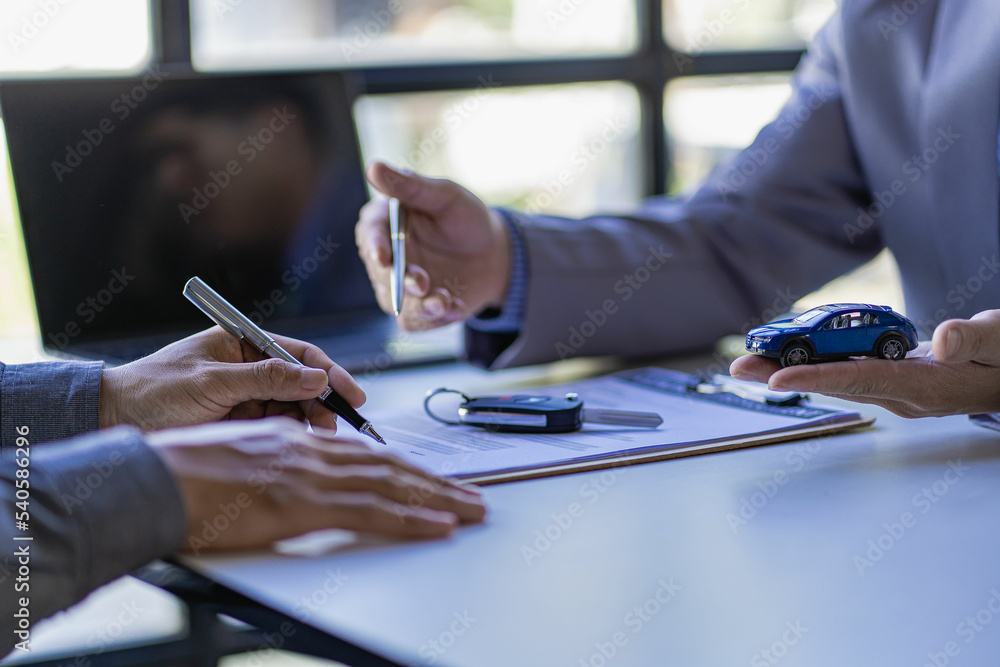 Obraz premium Car rental agent managers with new car owners sign a good rental agreement after passing vehicle financing.