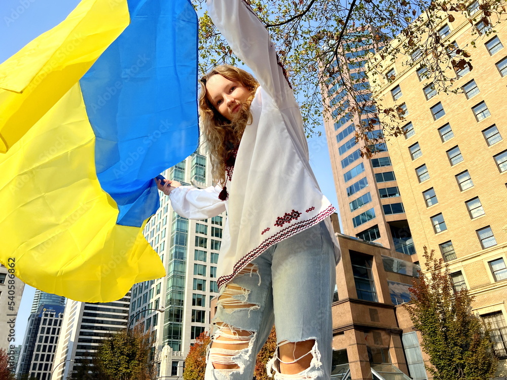 teenager covers the camera with a flag flashing yellow and blue