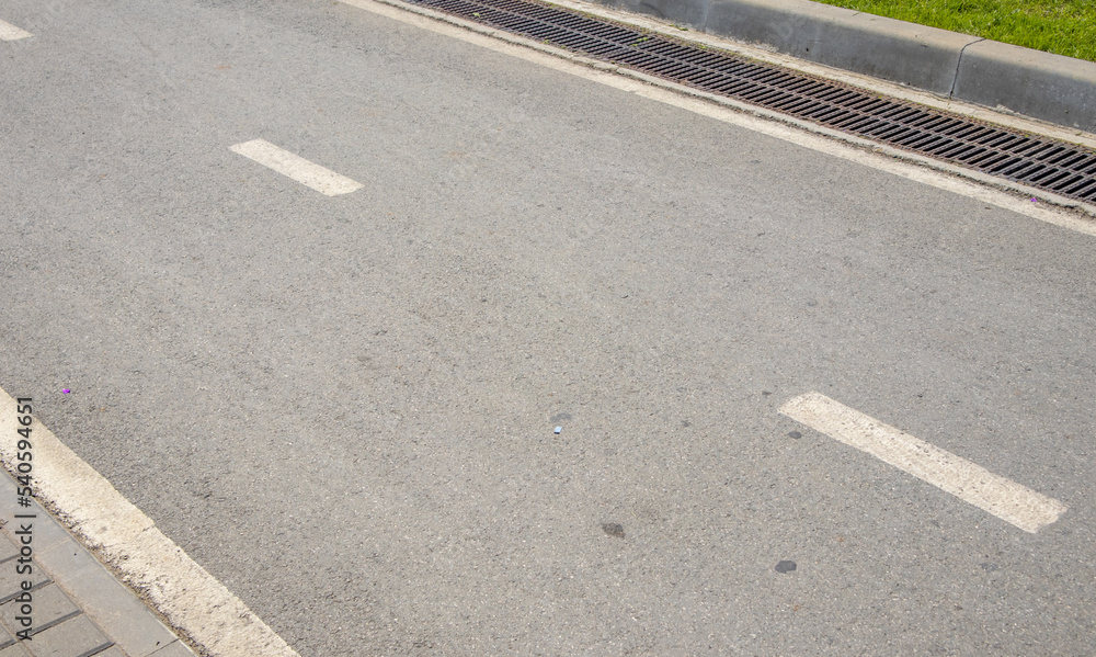 An intermittent lane marking line and the direction of traffic on an asphalt road with a copy of the space An intermittent lane marking line and the direction of traffic on an asphalt road with a copy of the space