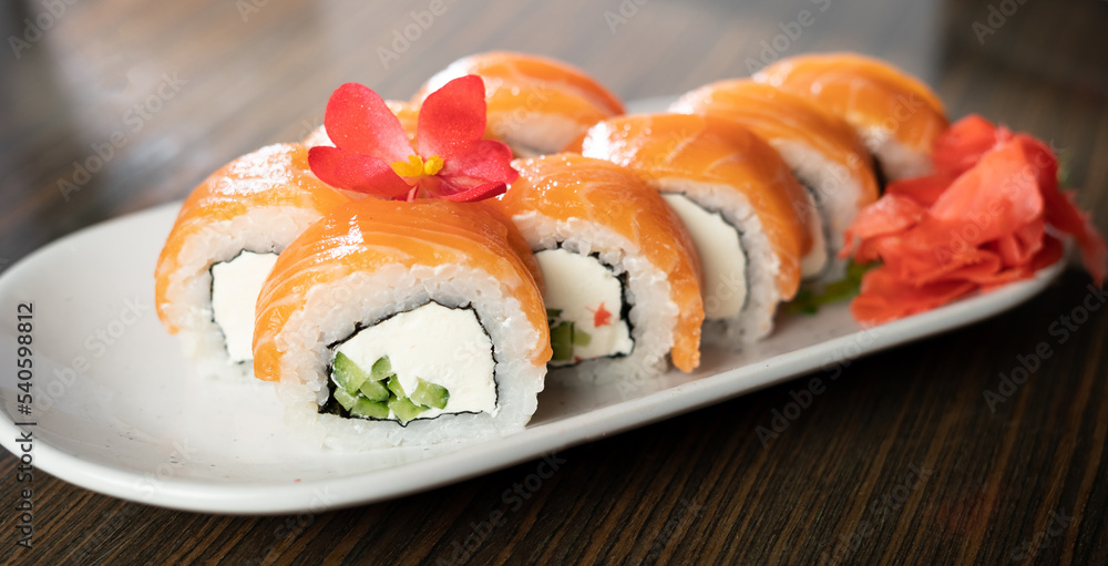 Philadelphia sushi roll with salmon cream cheese on a plate. Traditional Japanese food. Philadelphia sushi roll with salmon cream cheese on a plate. Traditional Japanese food.