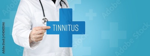 Tinnitus. Doctor holding blue cross with medical term on it. photo