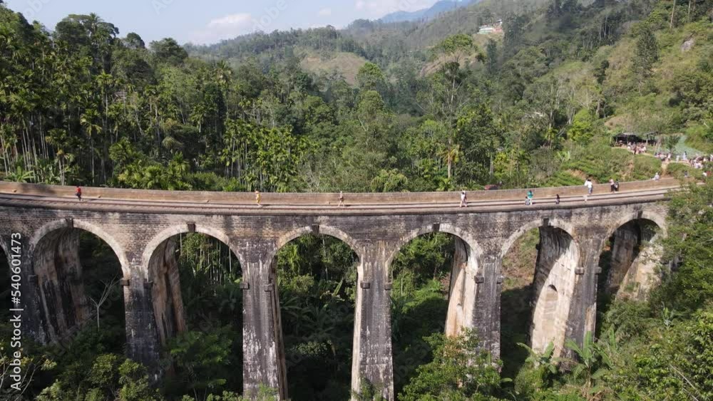 People Crossing The Famous Nine Arches Bridge In The Hill Country Of Ella In Sri Lanka. Aerial Drone Shot People Crossing The Famous Nine Arches Bridge In The Hill Country Of Ella In Sri Lanka. Aerial Drone Shot