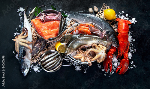 Photography Fresh fish and seafood assortment on black background, fish market