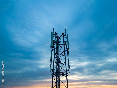 3G, 4G, 5G. Mobile phone base station Tower. Development of communication system in non-urban forest area with dark sunset or sunrise sky background. High quality photo