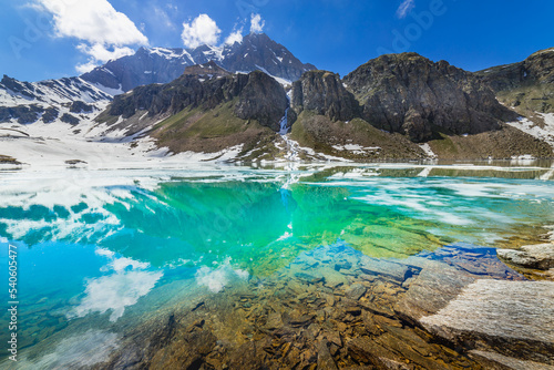 Fototapeta Naklejka Na Ścianę i Meble -  Alpine emerald lake and mountains at springtime, Gran Paradiso Alps, Italy
