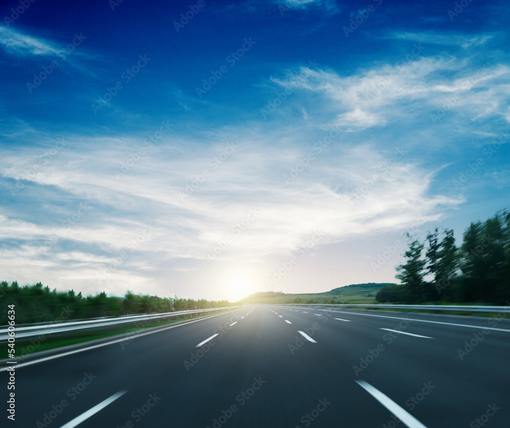 Fototapeta premium Motion blur of asphalt car road against blue sky