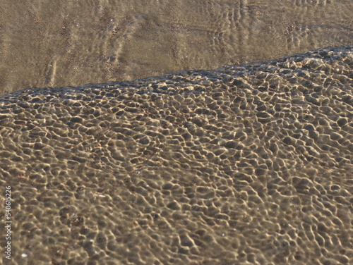 A transparent sea wave running over the sand © Любовь Челюканова