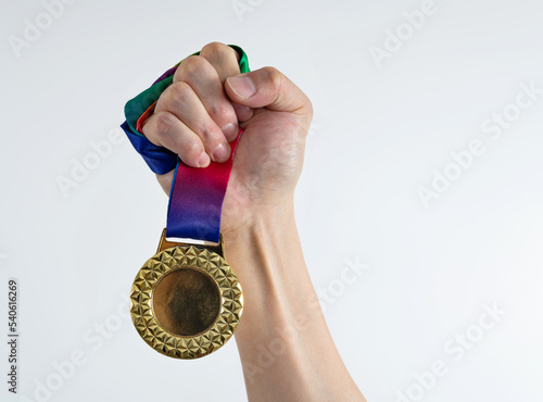 Woman hand holding a gold medal