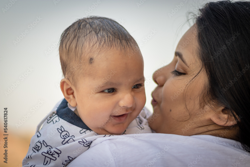 cute infant facial expression resting at mother shoulder from flat angle cute infant facial expression resting at mother shoulder from flat angle