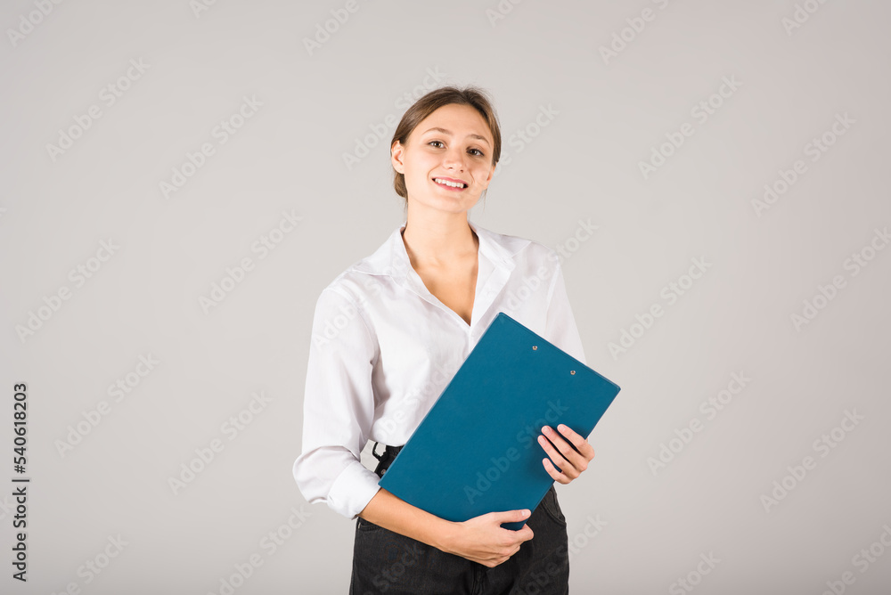 Portrait of a businesswoman with a clipboard in her hands on a gray background. Portrait of a businesswoman with a clipboard in her hands on a gray background.