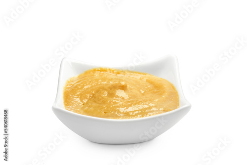 A bowl filled with mustard on a white background