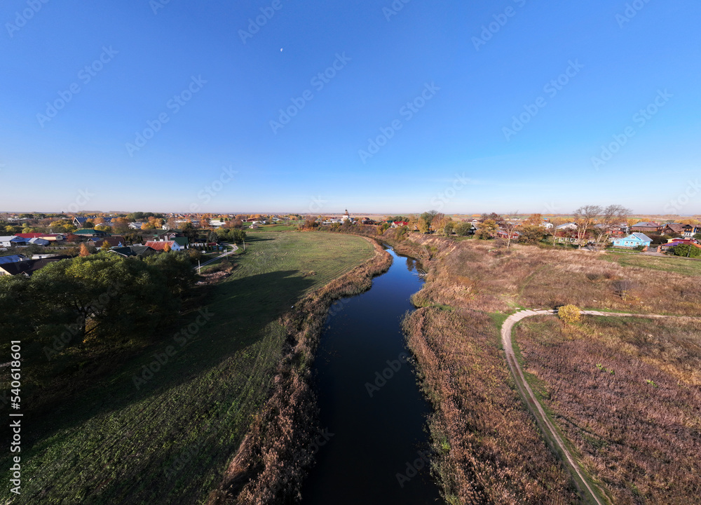 panoramic view from a drone of ancient buildings and fields and forests against the backdrop of autumn colors in Suzdal