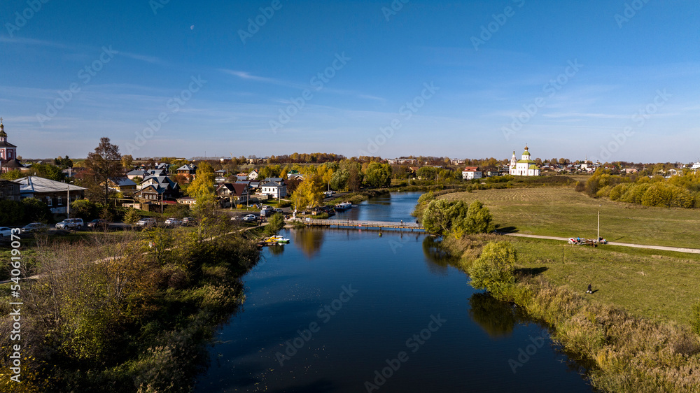 panoramic view from a drone of ancient buildings and fields and forests against the backdrop of autumn colors in Suzdal