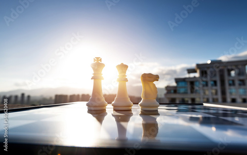 Chess king, queen and knight on city background