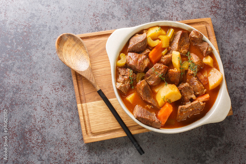 Traditional Irish Stew featuring succulent lamb, sweet root vegetables, and an irresistibly rich broth closeup in the pot on the table. Horizontal top view from above