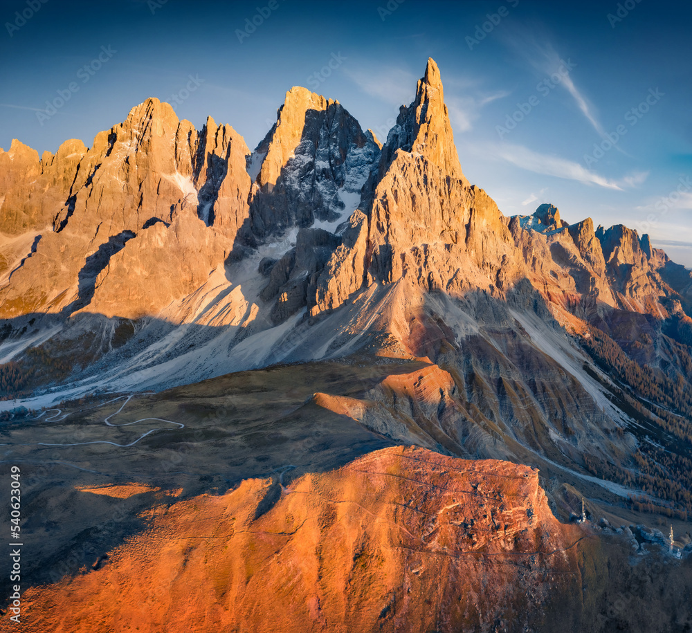 Breathtaking autumn scene of Dolomite Alps. Aerial evening view from flying drone of Cimon della Pala peak. Colorful landscape of Italy, Europe. Beauty of nature concept background..